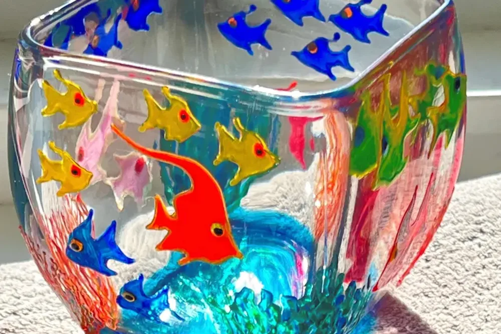 Hand-painted fish design on curved glass candle holder